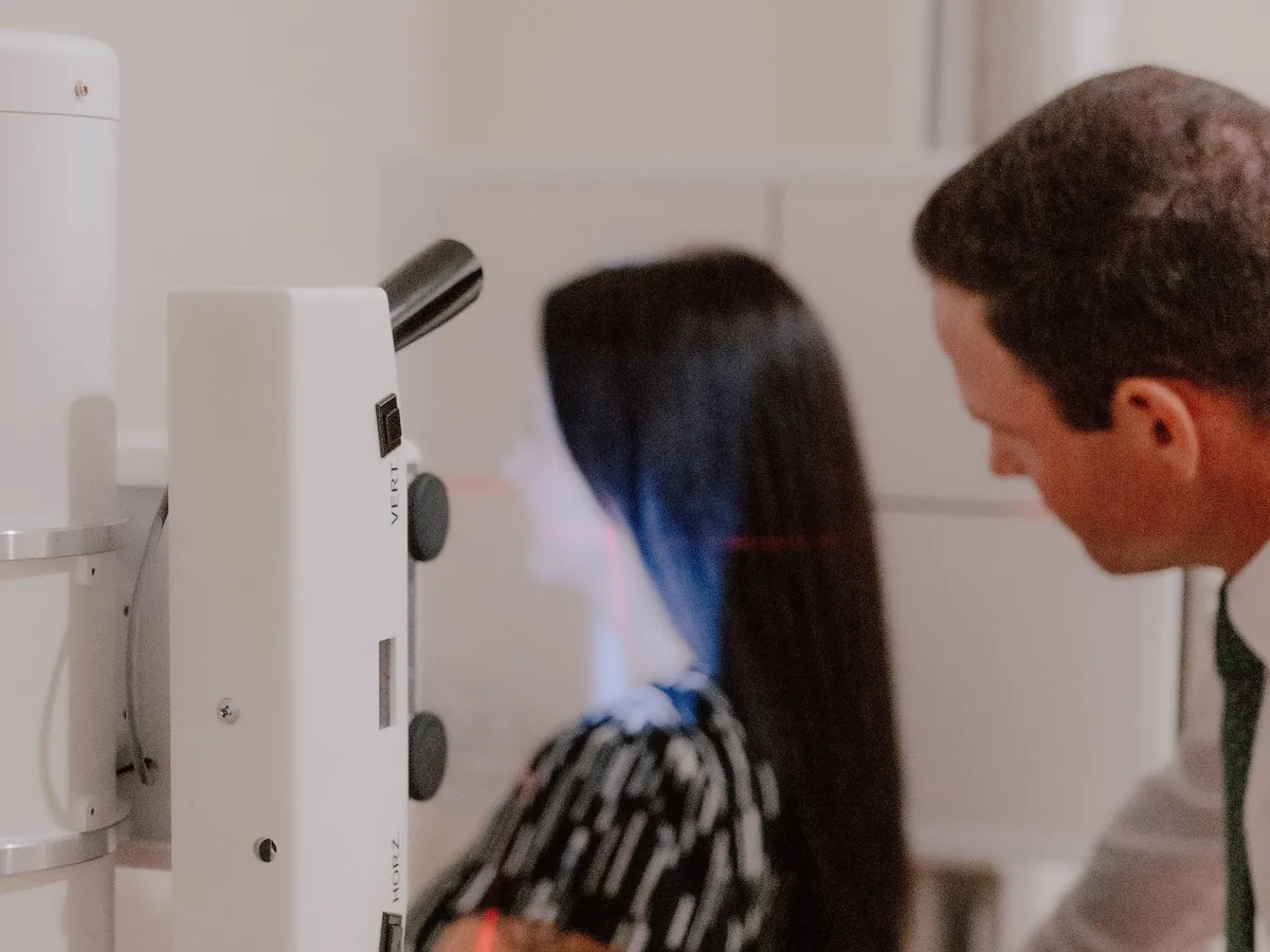 Dr. Collins positioning a patient in the upper cervical X-ray unit, alignment lasers visible