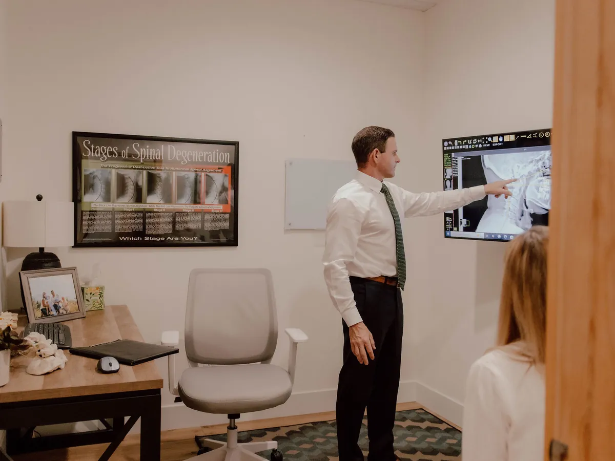 Dr. Collins reviewing a patient's X-ray on screen with them in the consultation room
